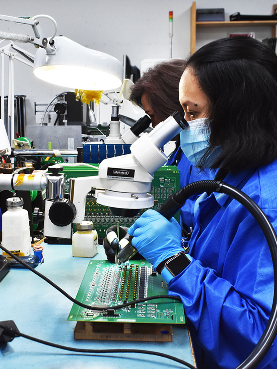 woman electrical engineer soldering a circuit board