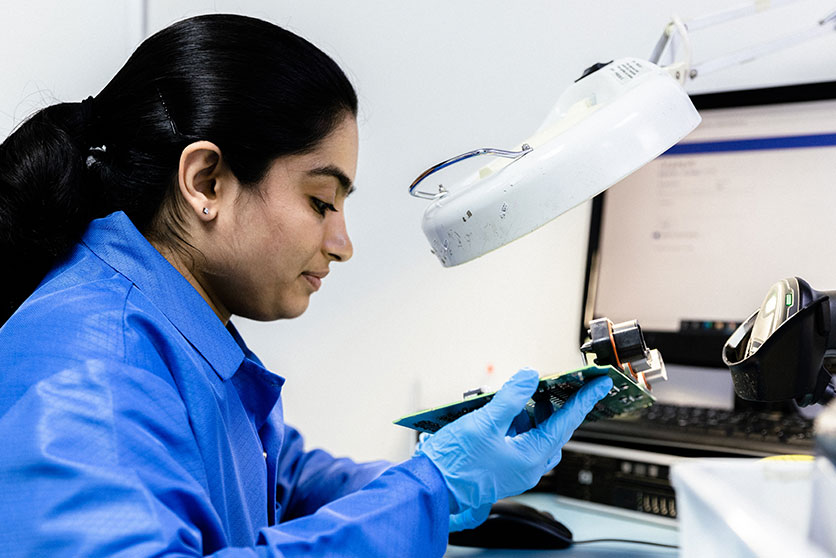 woman inspecting a circuit board
